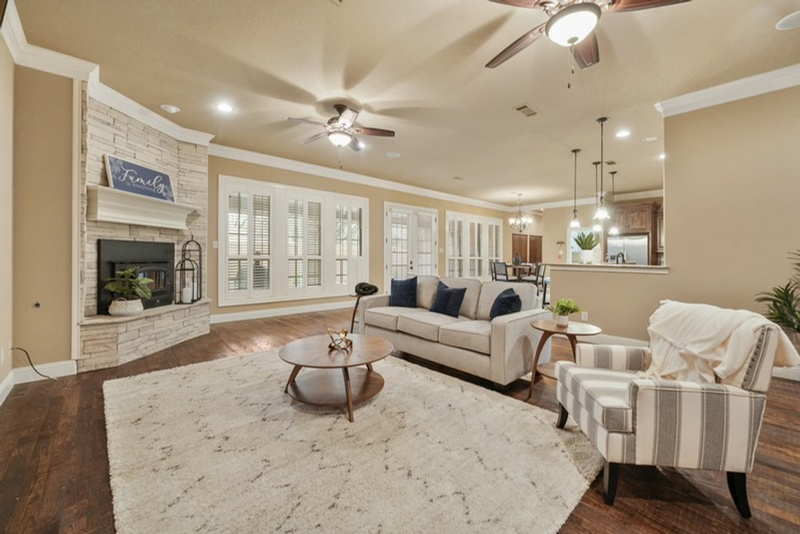 Vi'Lou staged open-concept living room with stone fireplace