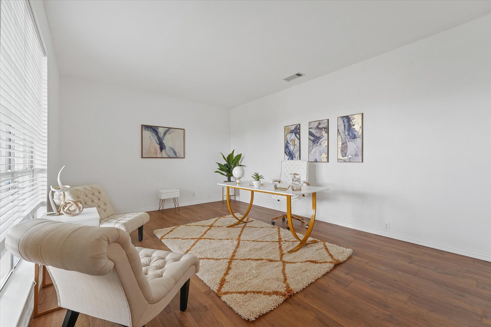 Vi'Lou staged home office with gold desk and abstract art