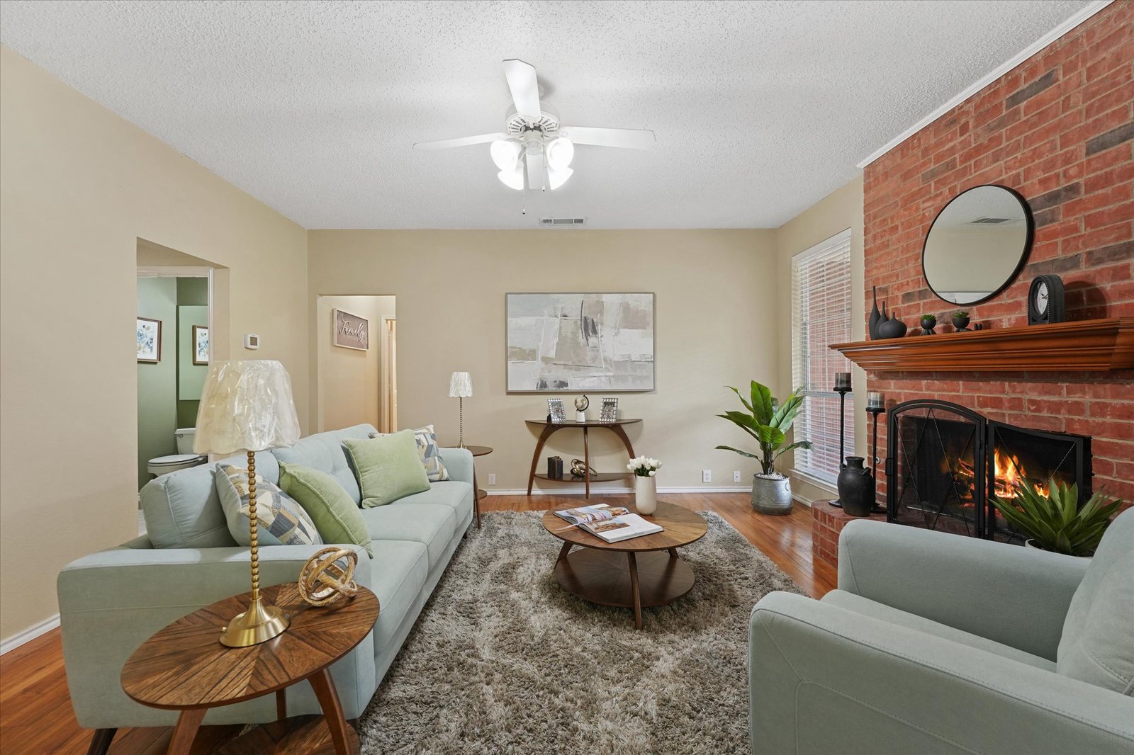 Vi'Lou staged living room with brick fireplace and warm seating